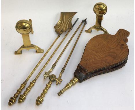 A pair of brass fire dogs; together with a set of brass fire tools (shovel, poker, tongs); and a set of wood, leather and bra