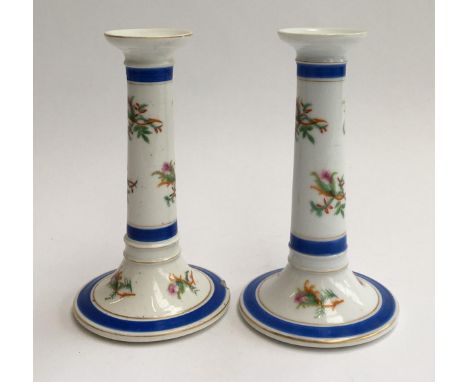 A pair of ceramic candlestick holders, decorated with floral sprays, heightened in gilt, marked '323' to base, 21cmH 