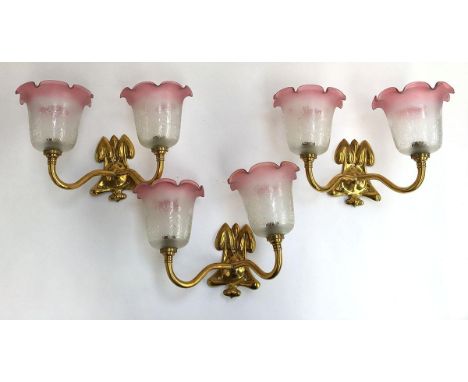 A set of three two-light fitting gilt metal sconces, with pink milk glass shades 