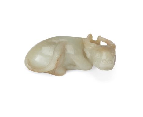 A Chinese pale celadon jade carving of a water buffaloLate Qing dynastyThe recumbent beast holding a sprig of grain in its mo
