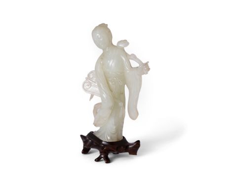 A Chinese pale jade carving of a standing beautyRepublic periodCarved from a pale stone, standing holding a fan and a ruyi sc
