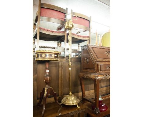 A BRASS OIL LAMP WITH RED GLASS SHADE OVER BRASS WELL ON SPREAD BASE WITH PAW FEET 