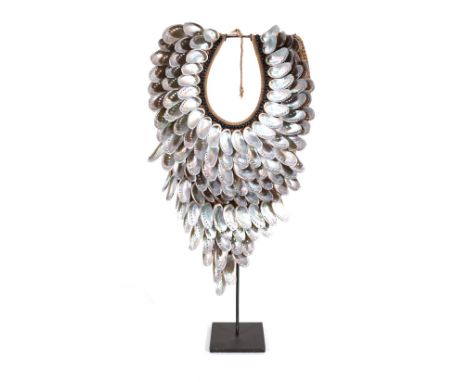 A tribal style necklace on stand, formed from abalone shells and rope, the overall height 69cm. 