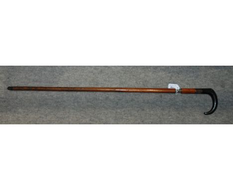 A single-shot walking stick gun, with pull action, with white metal machined ferrule with exposed button trigger, with animal