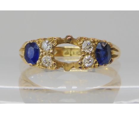 An 18ct gold blue gem and diamond ring, with scrolled setting (middle stone missing) size N, weight 4.1gms Condition Report: 