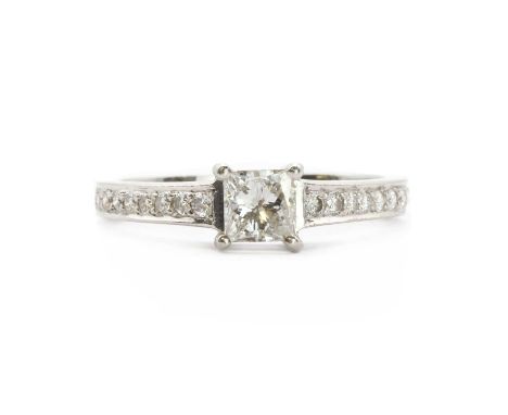 A platinum princess cut diamond ring, by Fred Ullmann,a princess cut diamond, claw set, to shoulders grain set with brilliant