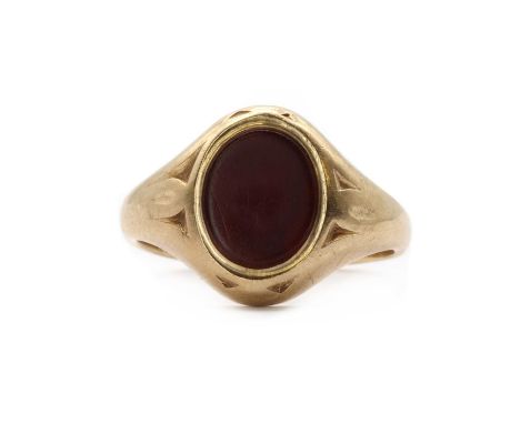 A 9ct gold cornelian signet ring, by Charles Green and Sons,an oval tablet cut cornelian, rub set, to patterned shoulders and