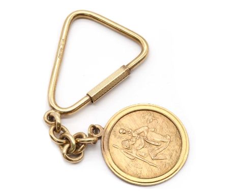 A 9ct gold St. Christopher key ring,a St. Christopher with a plain stepped surround, to a trace link chain with a triangular 