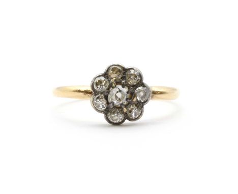 A gold diamond cluster ring,a daisy cluster of diamonds, with a central old European cut diamond, to a surround of old Europe