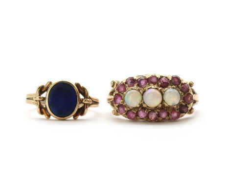 A gold opal and ruby landscape cluster ring, three round cabochon opals to surround of mixed cut rubies, to scroll shoulders 