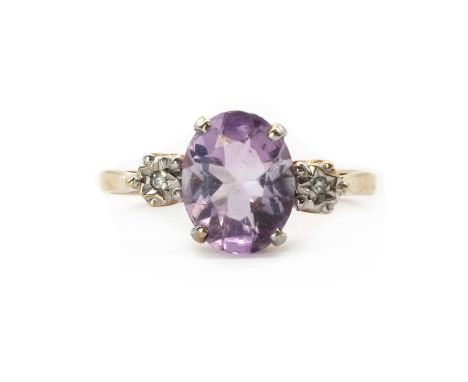 A 9ct gold amethyst and diamond three stone ring, an oval mixed cut amethyst, with an eight cut diamond grain set to an illus