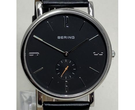 A gentleman's stainless steel Bering wristwatch 13709-402, on a leather strap, in a glass case, with guarantee and instructio