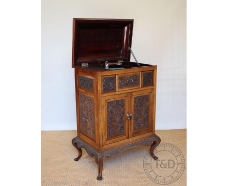 A pre-war Anglo-Indian carved rosewood gramophone cabinet, with hinged top above two doors enclosing a speaker, over two larg