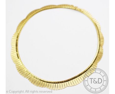 A yellow metal collarette necklace, of graduated and lobed form, with textured and polished finish and integral clasp with sa