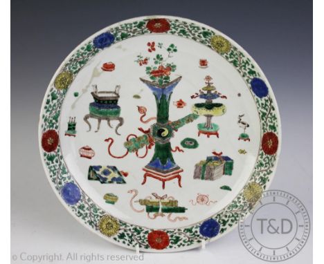 A Chinese 18th century famille verte charger, centrally decorated with antiques and precious objects within a chrysanthemum a