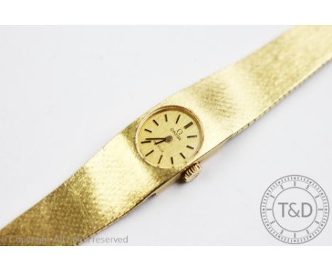 A ladies 18ct yellow gold Omega De Ville wristwatch, the rectangular case enclosing oval gold coloured dial with batons, inne