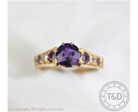 An amethyst and diamond ring, designed as a central untested amethyst within amethyst and diamond set shoulders, all set in y