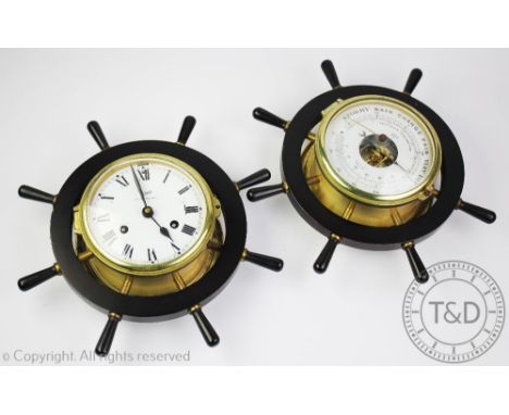 A Schatz brass bulkhead clock and barometer, within ships wheel mounts (one handle to wheel lacking), 33cm diam overall