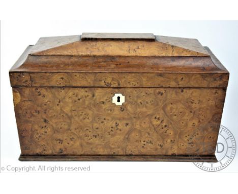 A Victorian burr walnut sarcophagus shaped tea caddy, the hinged cover opening to reveal to tea containers, lacking mixing bo