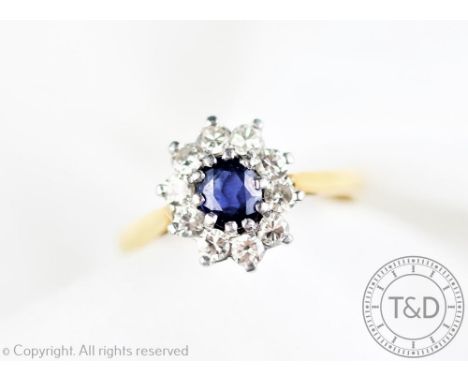 An untested sapphire and diamond cluster ring, the central oval untested sapphire within a surround of ten brilliant cut diam