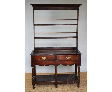 A George III style oak dresser of small proportions, with two tier open plate rack above two drawers and a pot shelf, on turn