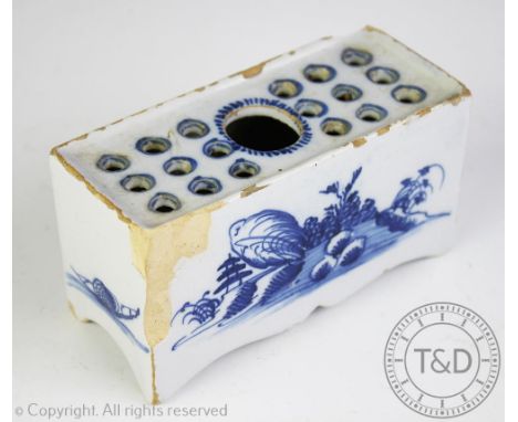 A 18th century blue and white delft flower brick, the rectangular brick with pierced top decorated to the side with floral sp