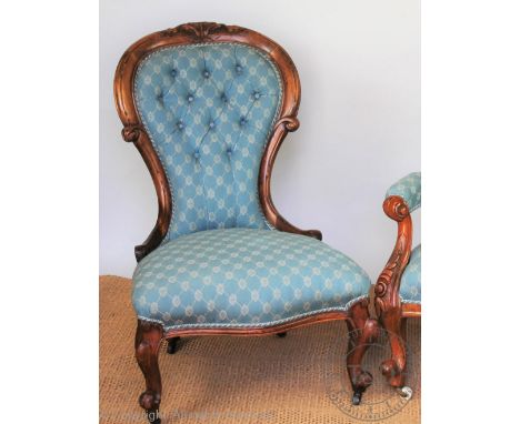 A Victorian carved walnut button back salon chair, with patterned blue upholstery, on scroll legs, 88cm H
