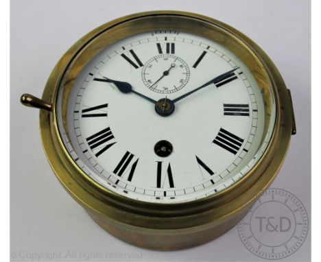 An early 20th century brass bulk head time piece, Roman numeral enamel dial with subsidiary seconds dial, 15cm diam
