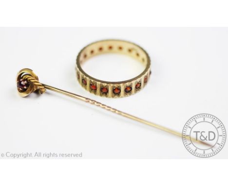 A garnet set 9ct gold full eternity ring, weight 3.4gms and a ruby set stick pin in fitted case (2) CONDITION REPORT: Ring si