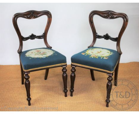 A set of six William IV carved rosewood dining chairs, with buckle shaped backs and blue upholstered seats, on turned and tap