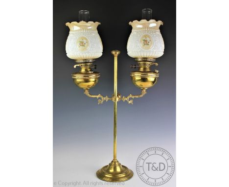 A large late Victorian brass twin branch desk oil lantern, the central stem flanked by two adjustable oil reservoirs, burners
