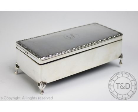 A silver jewellery casket, Walker & Hall, Sheffield 1922, the rectangular box and hinged cover with engine turned detail and 