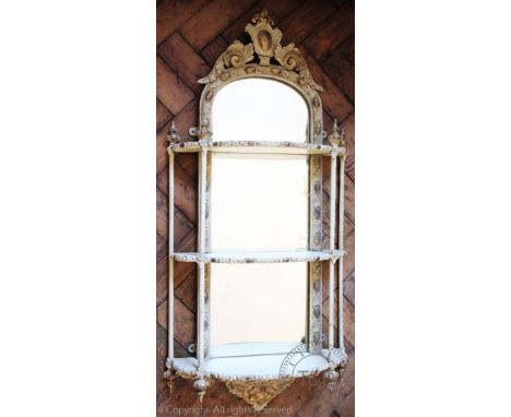 A Regency style mirror back gilt wood and gesso hanging shelf, with three tiers and arched mirror plate surmounted with shell