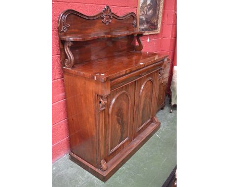 A Victorian mahogany chiffonier, carved gallery, serpentine shelf, S-scroll supports to superstructure. long drawer over two 