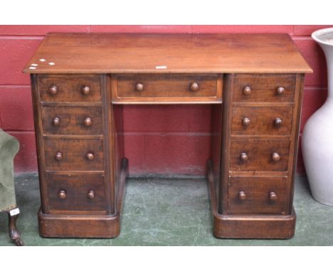 A Victorian mahogany kneehole desk, moulded top, one long drawer over kneehole flanked by four drawer pedestals, button handl