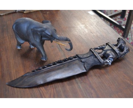 A carved wooden Indian elephant and lion knife; an elephant with articulated trunk (2)