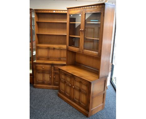 An Ercol light oak display cabinet, two glazed doors over recess to top, two panel door to base; another, shelving over fall 