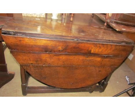 A 19th century oak gate leg dining table with an oval planked top on tapering legs