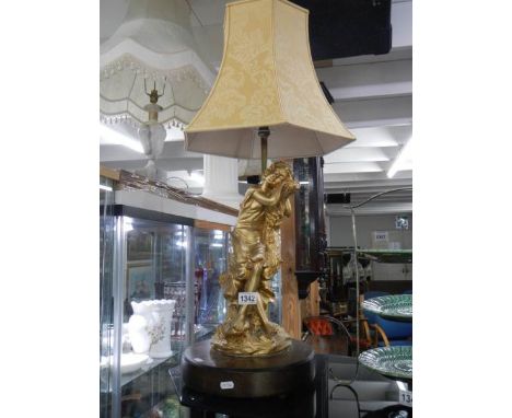 A large figural table lamp with shade.