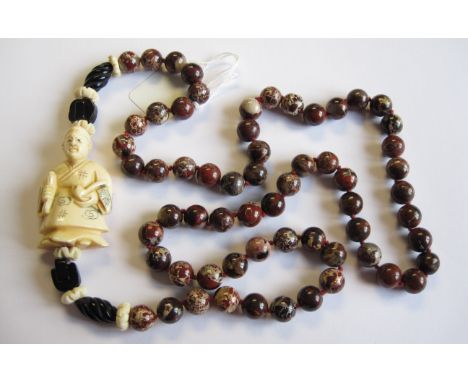 An Agate Bead Necklace with carved ivory netsuke