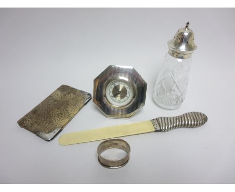 A silver handled ivory Page Turner, silver lidded cut glass Sugar Caster, silver framed octagonal Mantel Clock and silver mou