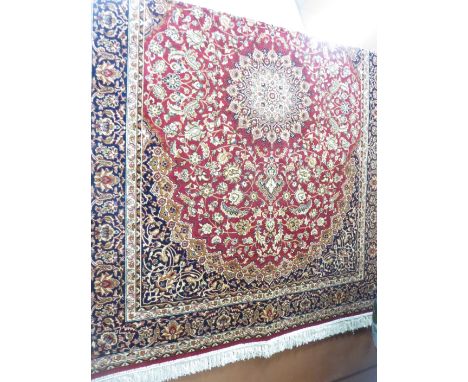 A red ground Keshan Carpet with central star design, 7ft 6in x 5ft 4in