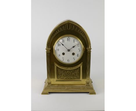 A French brass Mantel Clock with arched top and circular dial above a scrollwork and foliate panel, 11 1/2in H