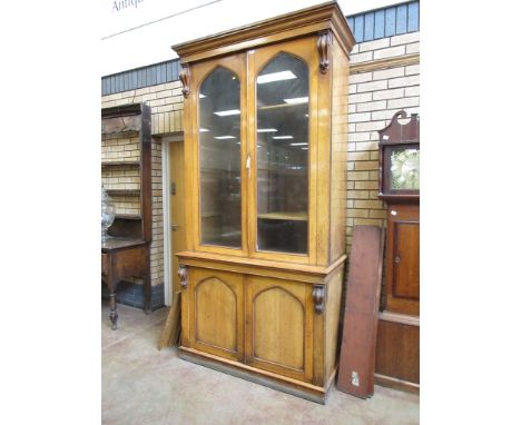 A Victorian gothic style light oak Document Cabinet with pair of glazed doors above pair of arched panelled doors flanked by 