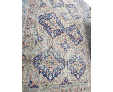 A Turkish Carpet with cream ground decorated six blue lozenges within a pale blue border with salmon tramlines, 12ft 10in x 1
