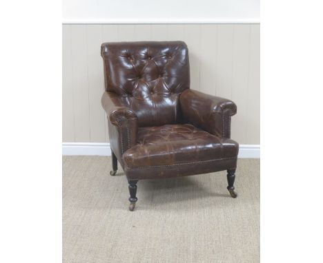 A 19th Century brown leather button back and seated Armchair on turned mahogany supports and ceramic casters