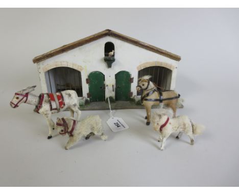 A German made skin covered Donkey with nodding head, three skin covered horses and a wooden stable. All circa 1910. Sold with