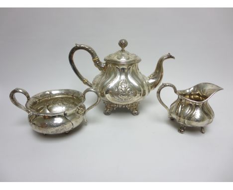 A Danish silver three piece circular Tea Service with floral embossing, shaped feet, flower finial to teapot, maker: P Hertz,