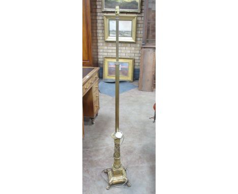 A brass Standard Lamp with reeded column on base with pierced and scrolled section on a square base with four scroll moulded 