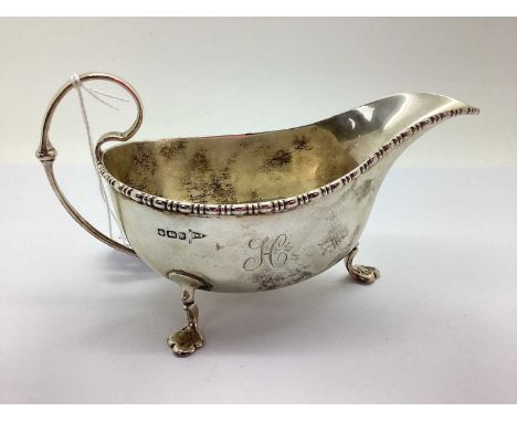 Walker &amp; Hall; A Hallmarked Silver Sauce Boat, Sheffield 1915, with bead and reel rim, scroll cap handle and raised on th